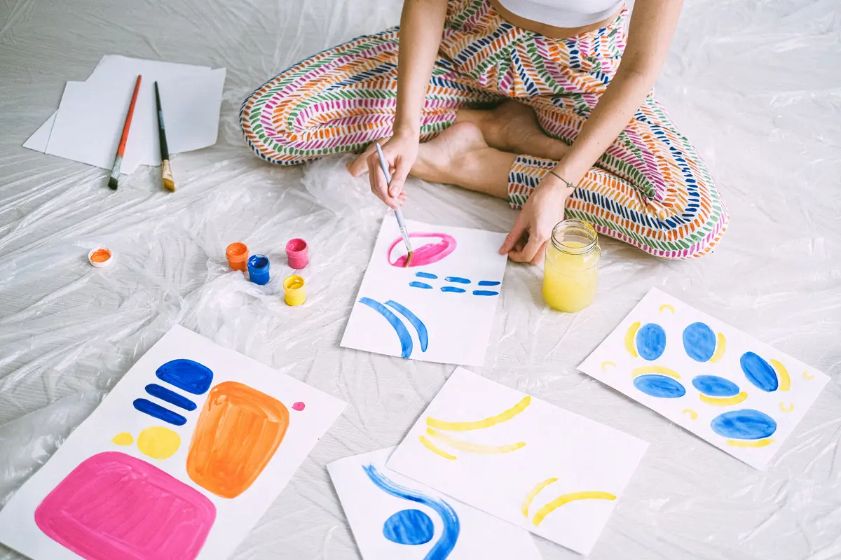 Woman painting colorful artwork on paper